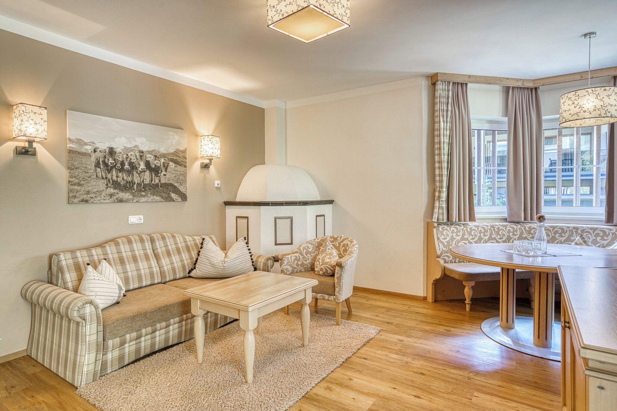 Uma sala de estar com sofá, uma mesa, um banco, lareira e um espaço de jantar com banco e mesa.