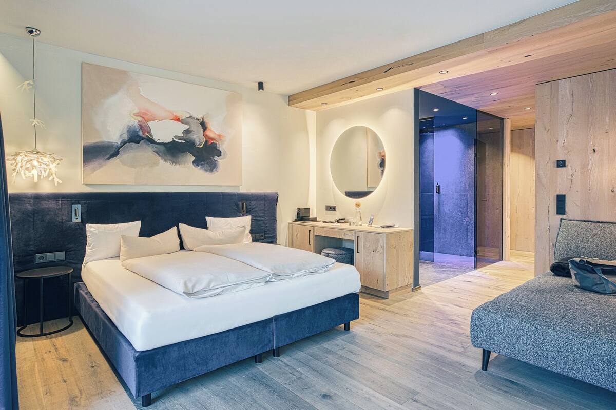Ein modernes Schlafzimmer mit einem großen Bett, einem Nachttisch und einem Spiegel.