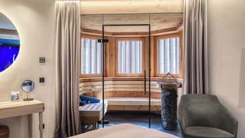 A room with a bed, a desk with a mirror, a chair, a stone table, and a window with curtains.