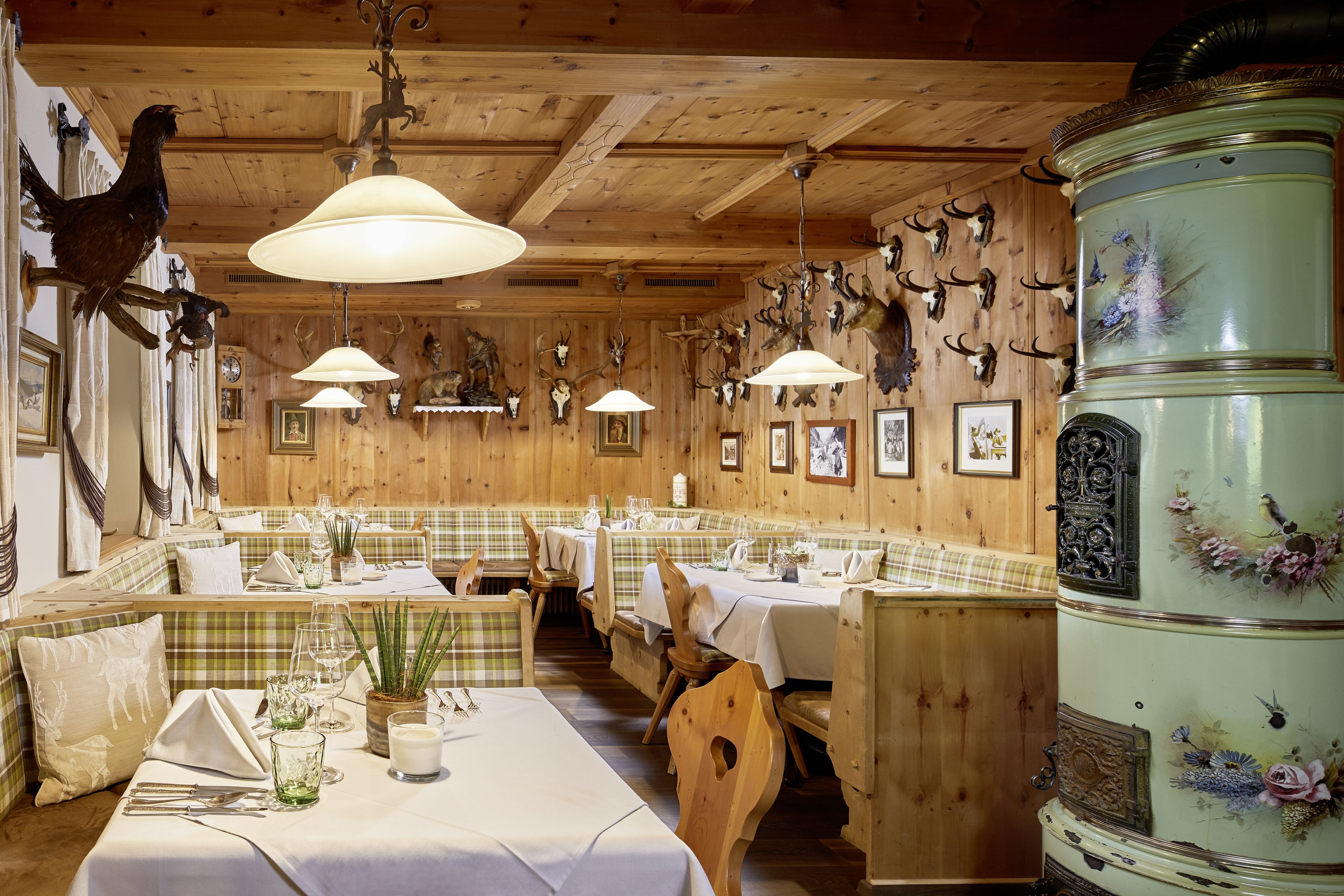 A restaurant with wooden walls, mounted animal heads, and a green decorative barrel.