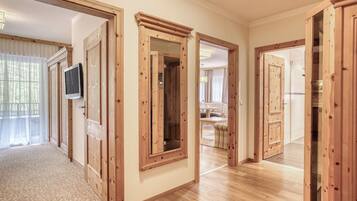 A hallway with wooden doors and a television mounted on the wall.