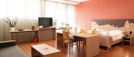 Una habitación de hotel moderna con cama, escritorio y zona de estar.