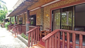 A row of wooden buildings with large windows and a stone facade. - Cooper's Beach Resort (Puerto Princesa)