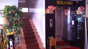 A hotel entrance with a staircase, a welcome sign, and a red carpet. - Sky Park Guesthouse (Phnom Penh)