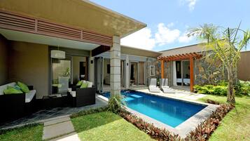 Una piscina al aire libre, sillones reclinables de piscina