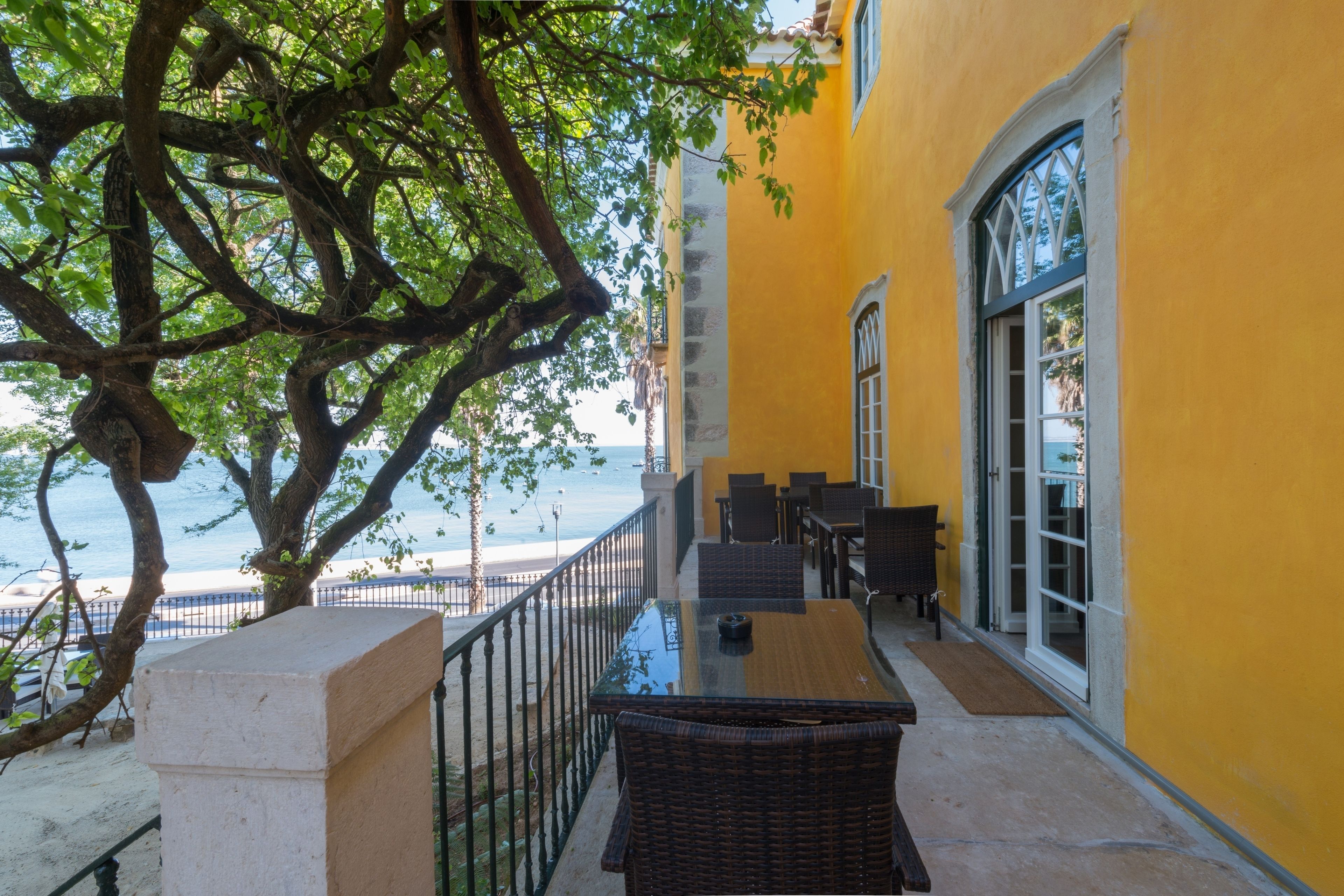 Un balcon avec une table et des chaises, donnant sur une plage.