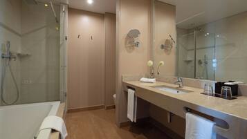 A modern bathroom with a glass-enclosed shower, a bathtub, and a vanity with a large mirror.