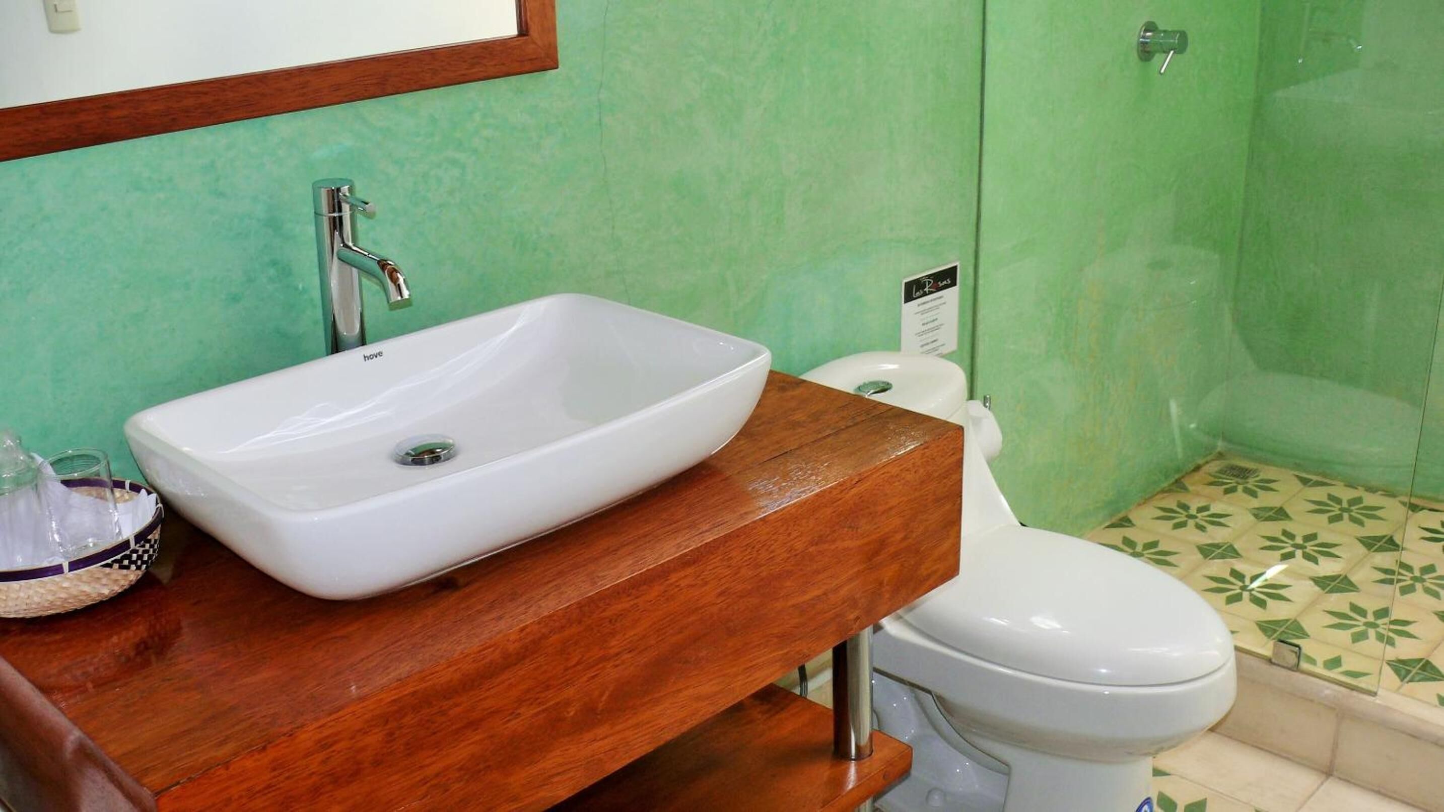 A bathroom with a white sink, wooden vanity, and a toilet.