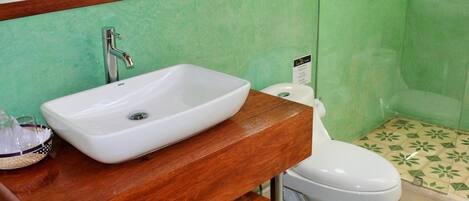 A bathroom with a white sink, wooden vanity, and a toilet.