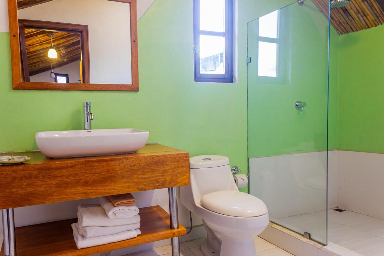 Une salle de bain avec un meuble-lavabo en bois, un lavabo blanc et des toilettes.