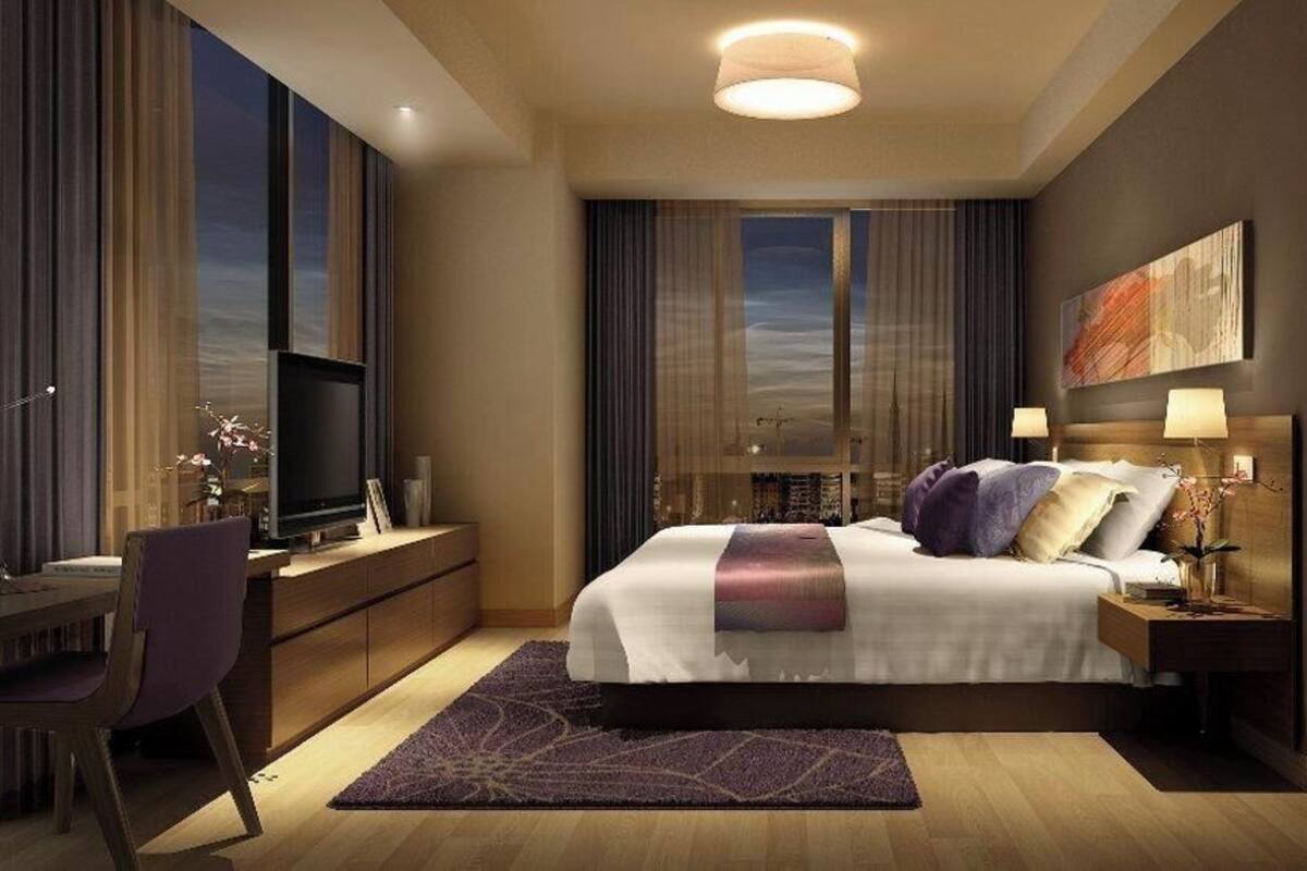 Et moderne hotelværelse med en stor seng, et skrivebord og et fjernsyn.