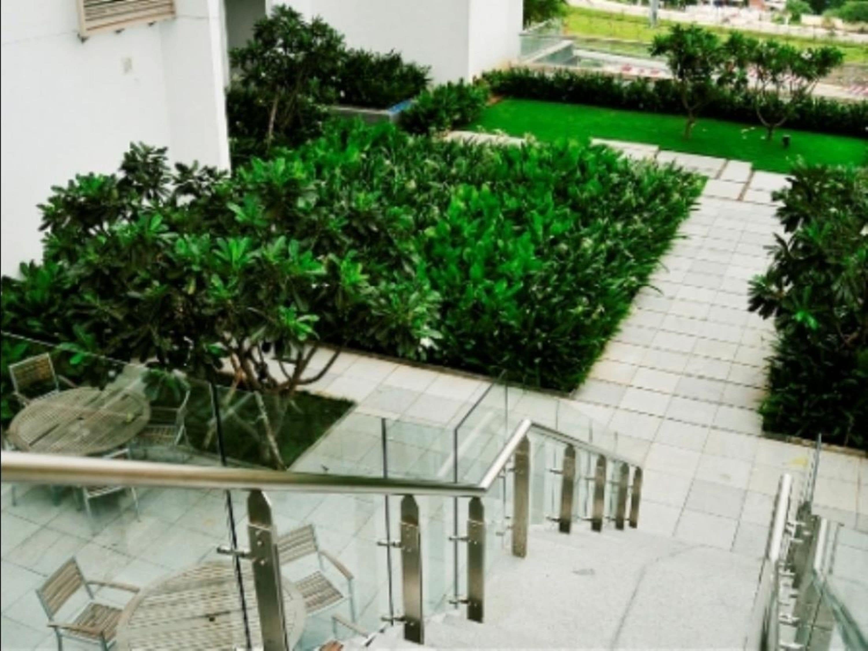 Un edificio moderno con una escalera de cristal que conduce a una zona de estar con sillas y mesas.