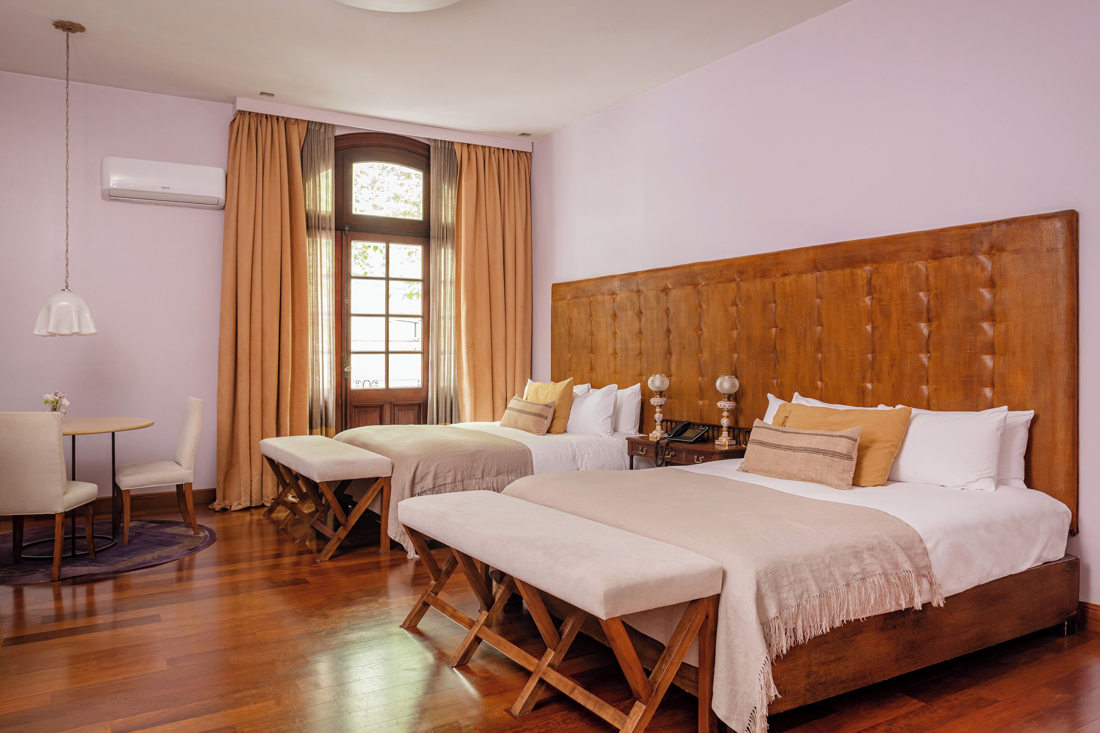 A hotel room with a large bed, two bedside tables, a desk, and a chair.