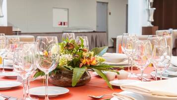 A dining table set with wine glasses, plates, and a centerpiece of flowers.