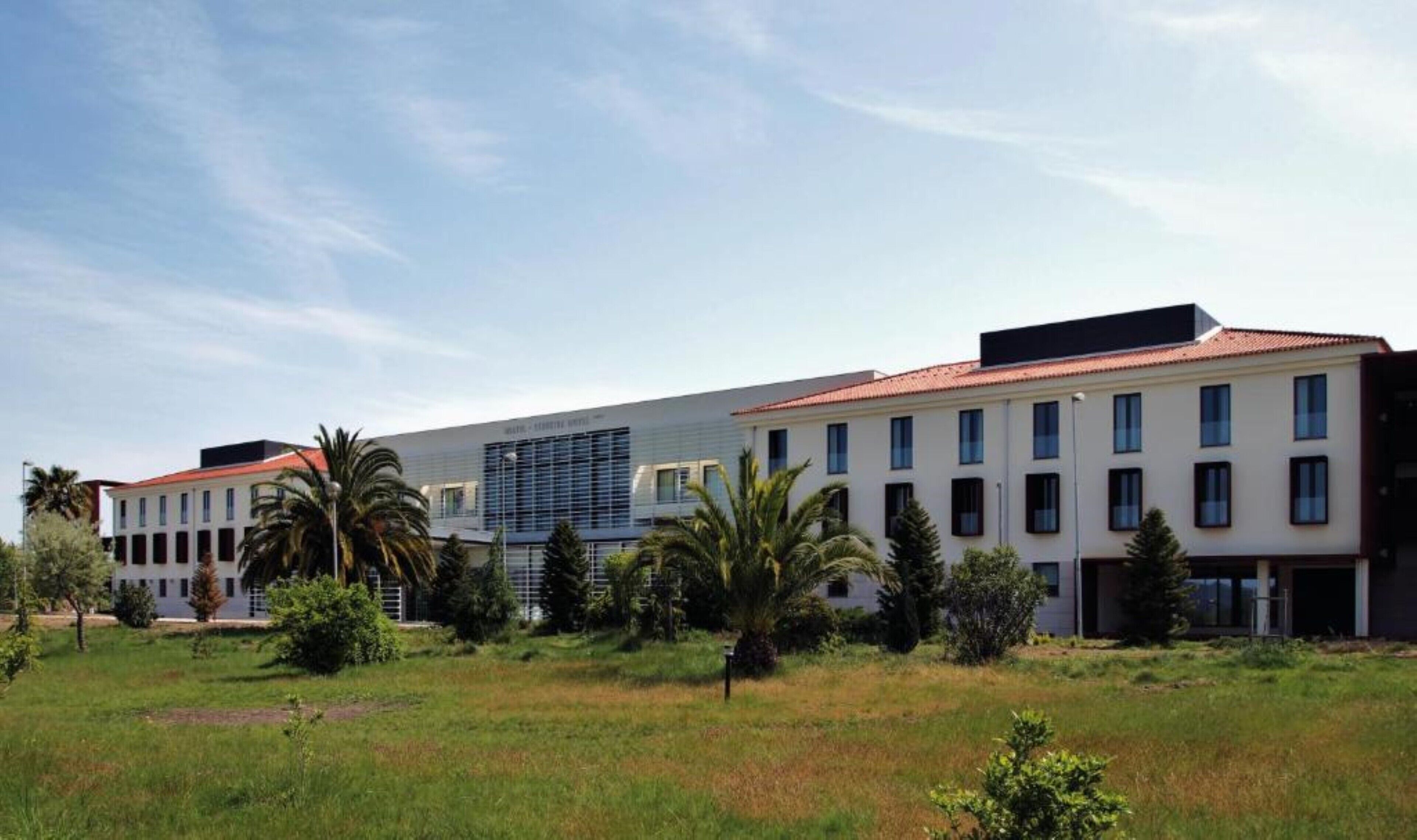 Un hotel moderno que combina arquitectura tradicional y contemporánea, con varios edificios que presentan diferentes estilos de ventanas y una estructura central con una fachada única.