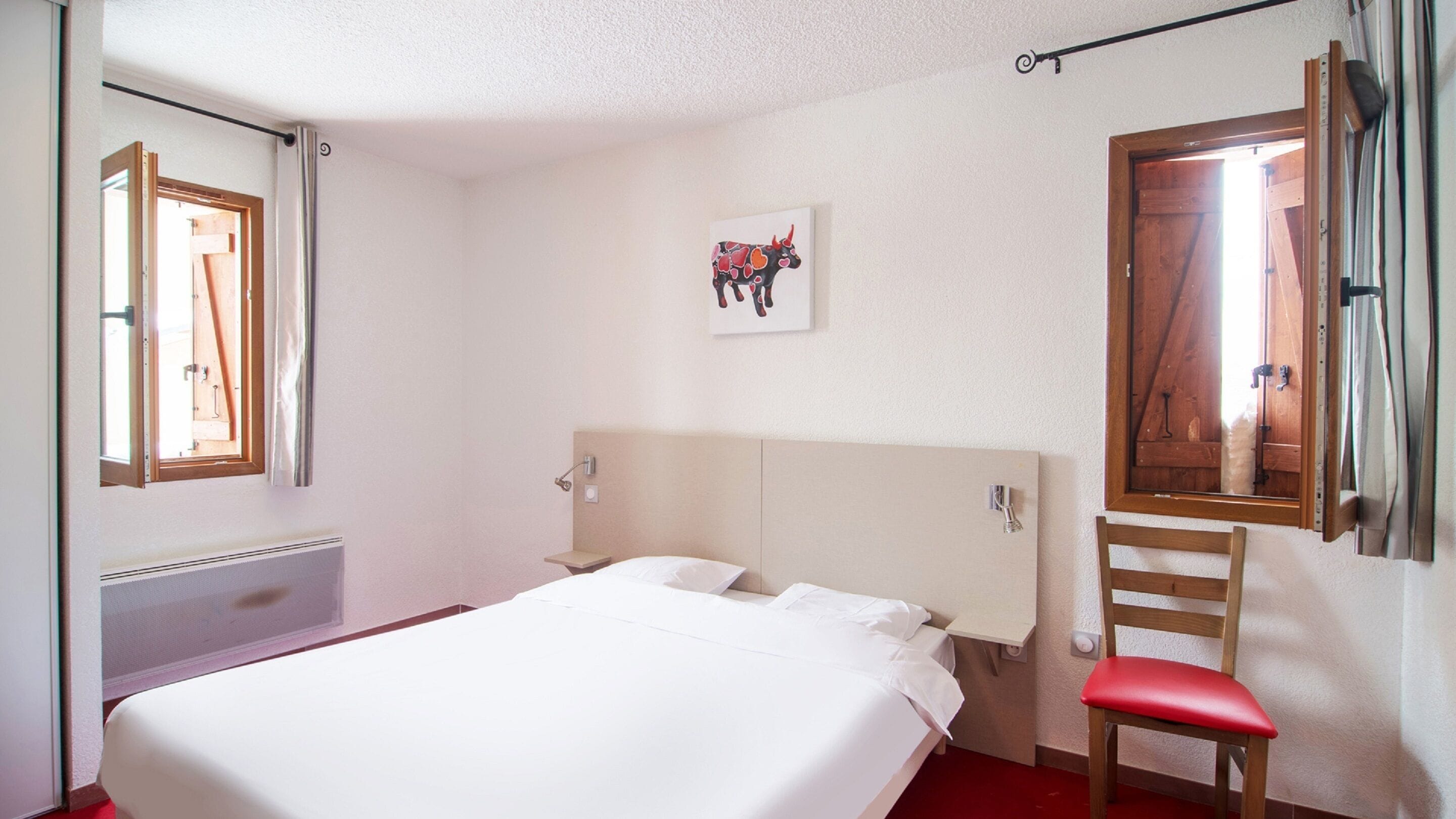 A bedroom with a bed, a chair, a window, and a door.
