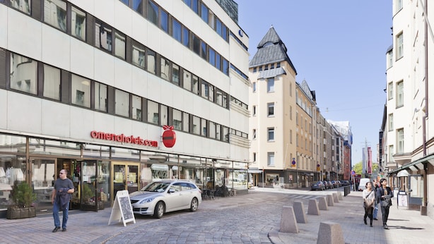 A hotel with a modern facade, large windows, and a prominent red logo. - Omena Hotel Helsinki City Center (Helsinki)