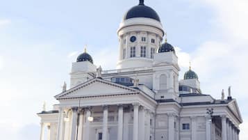 Un grand bâtiment blanc, doté de plusieurs dômes et de colonnes, qui semble être un monument historique ou culturel important.