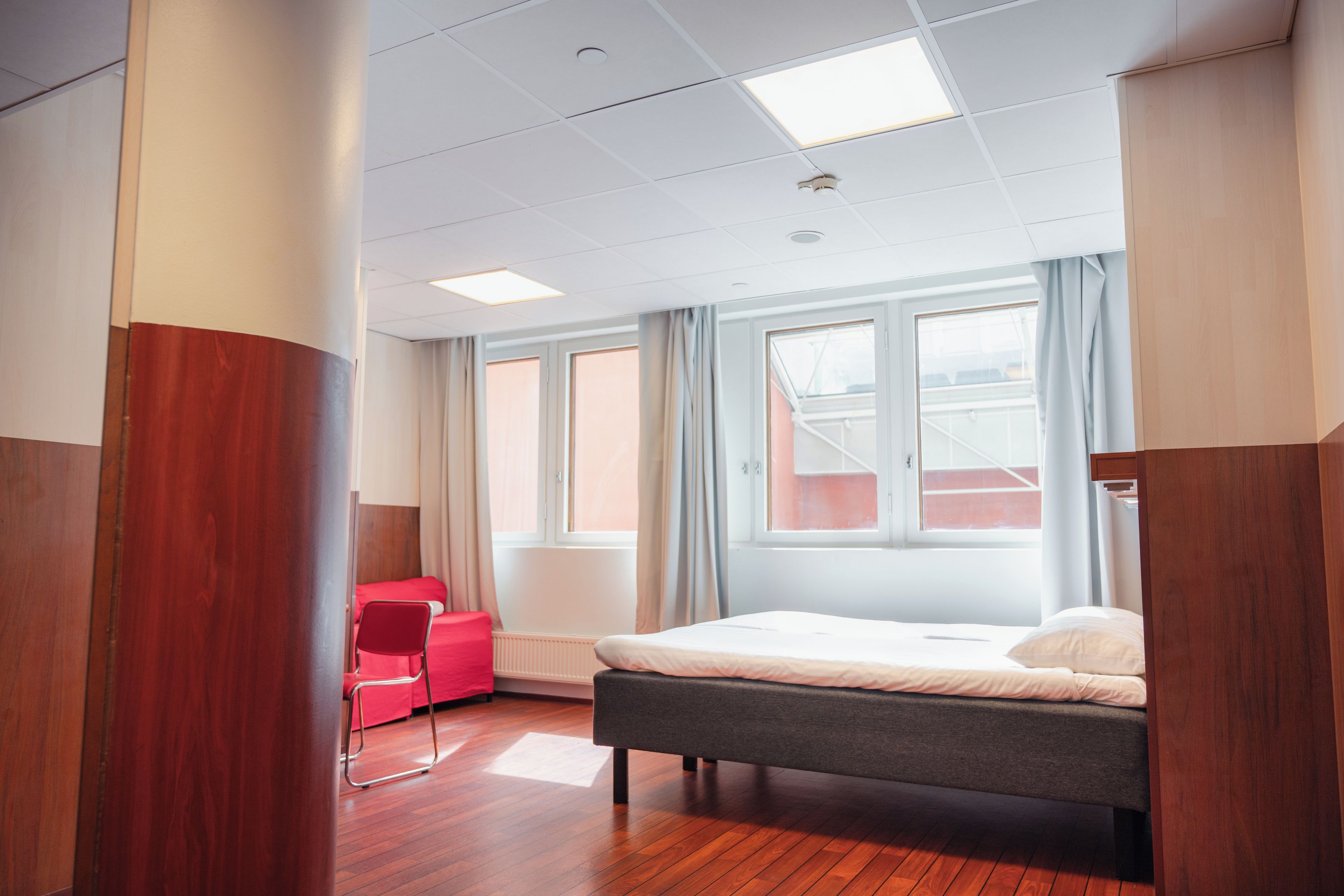 A hotel room with a bed, a desk, and a chair.
