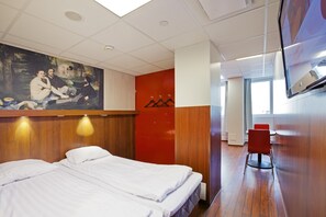 A hotel room with two beds, a painting on the wall, a red wall, a TV, and a chair. - Omena Hotel Helsinki City Center (Helsinki)