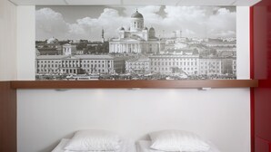 A bedroom with two beds, a large cityscape painting above, and a red wardrobe to the right. - Omena Hotel Helsinki City Center (Helsinki)