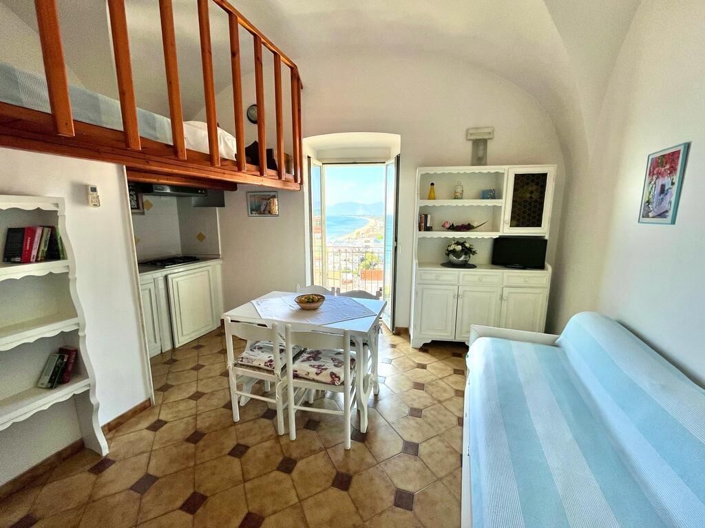 Un espacio habitable compacto con comedor, kitchenette y sofá.