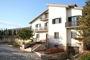 A two-story building with a stone facade, multiple balconies, and a stone-paved courtyard. - B&B Villa Ruberto (San Giovanni Rotondo)