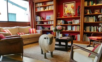 Una sala de estar acogedora con un sofá, una mesa de centro y una estantería llena de libros.