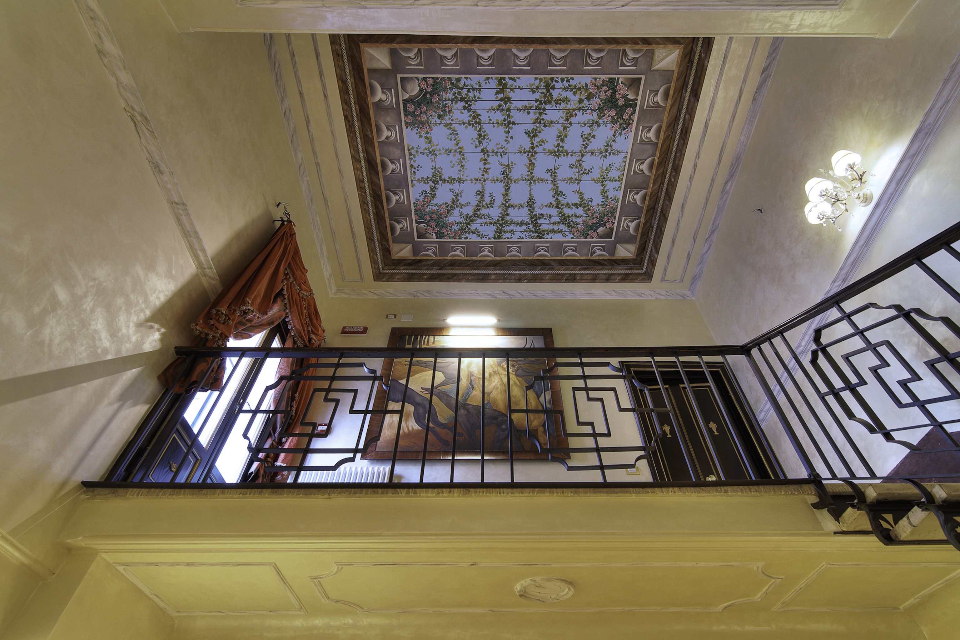 A staircase with a decorative ceiling and a view of the outside.