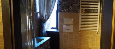Un baño con inodoro, lavamanos y zona de ducha.