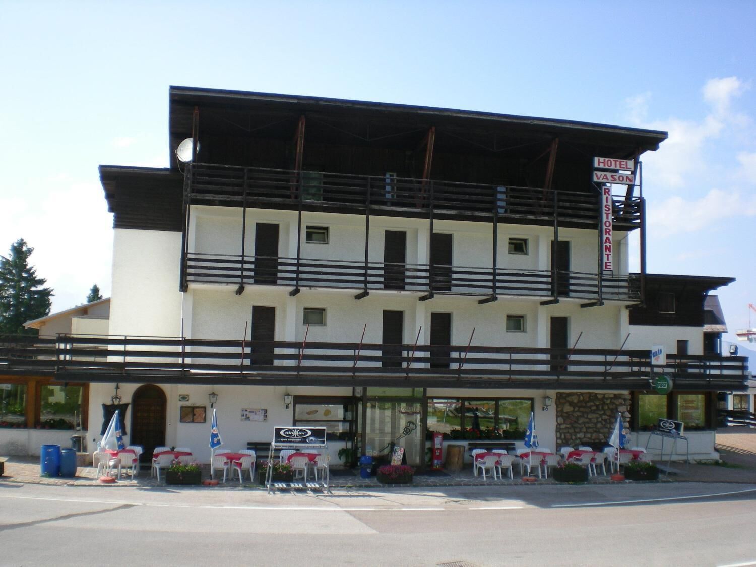 A two-story building with a sign for a hotel and restaurant.