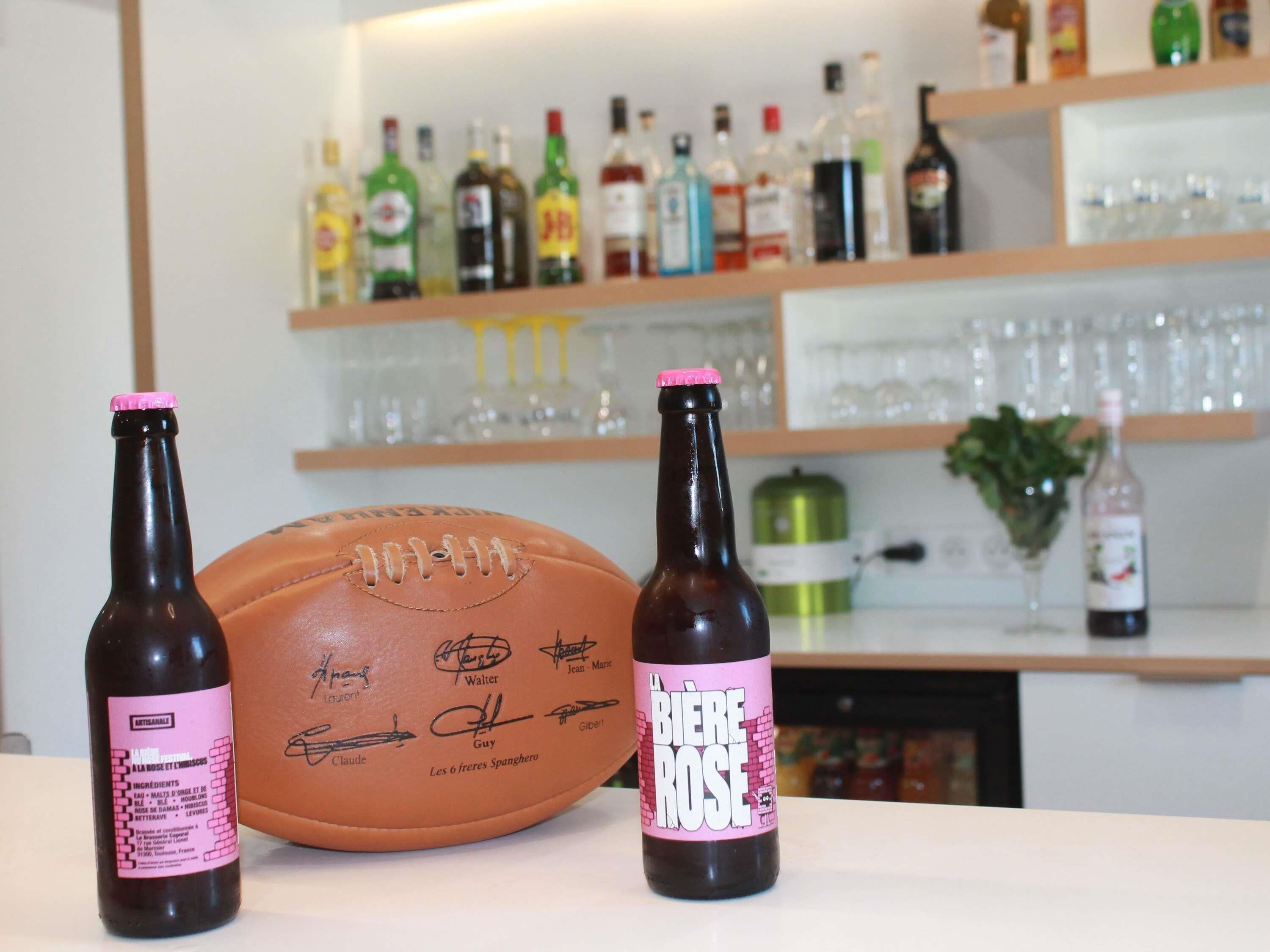 A table with two bottles of beer and a signed football.
