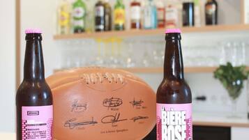 Two bottles of beer with pink labels and a signed football in the foreground.