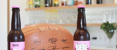 Two bottles of beer with pink labels and a signed football in the foreground.