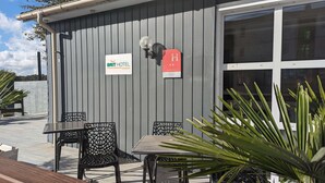 A BRIT HOTEL sign, outdoor seating area with metal chairs, and a red mailbox. - Brit Hotel Rouen Barentin (Barentin)