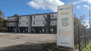 Een Brit Hotel bord met faciliteiten zoals WIFI, een kleine kitchenette, gratis parkeergelegenheid en laadpunten voor elektrische voertuigen.