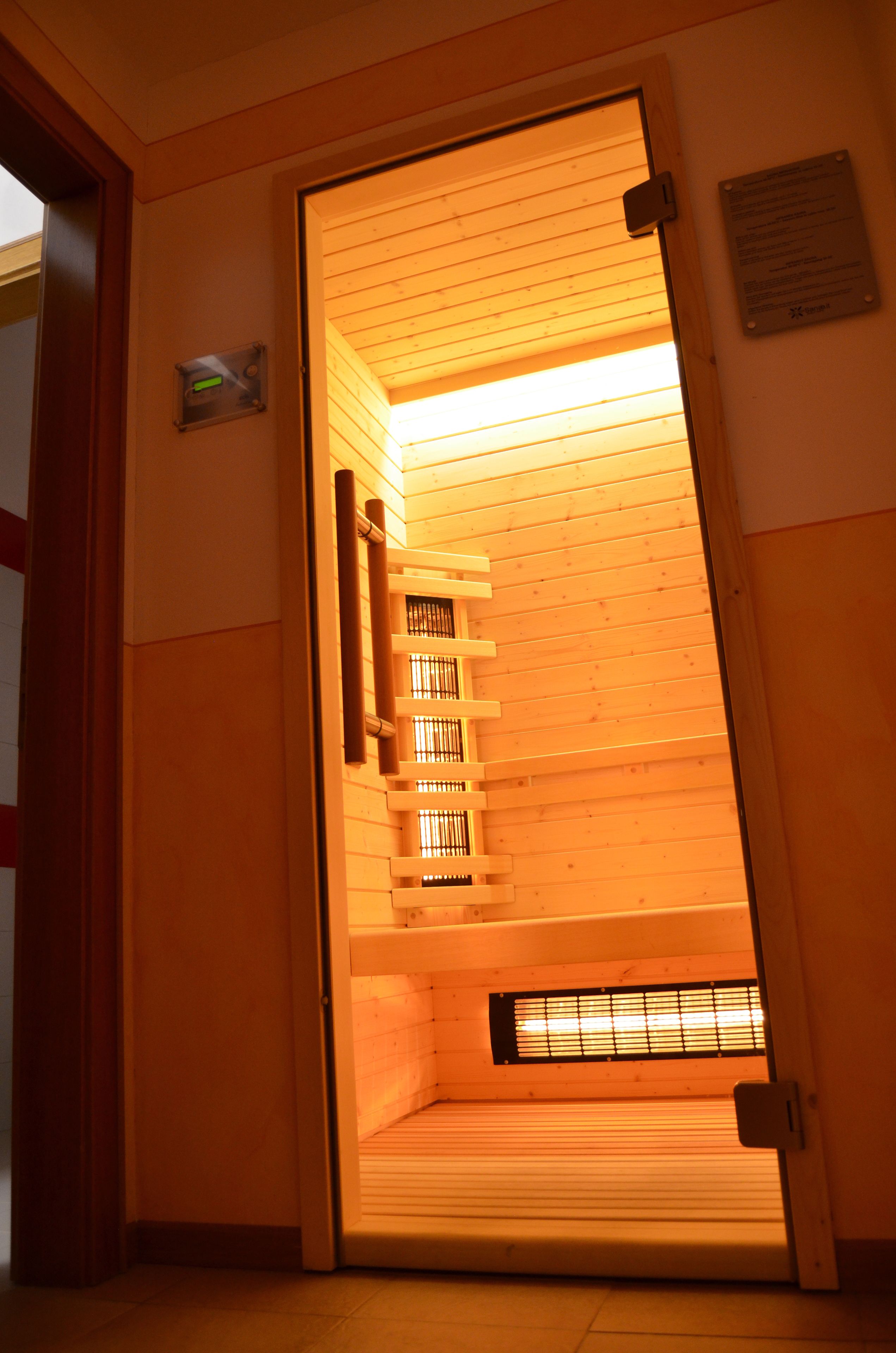 A sauna room with wooden slats and a bench.