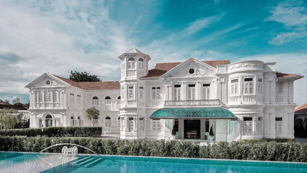 A large, white colonial-style building with a swimming pool in front. - Macalister Mansion (George Town)
