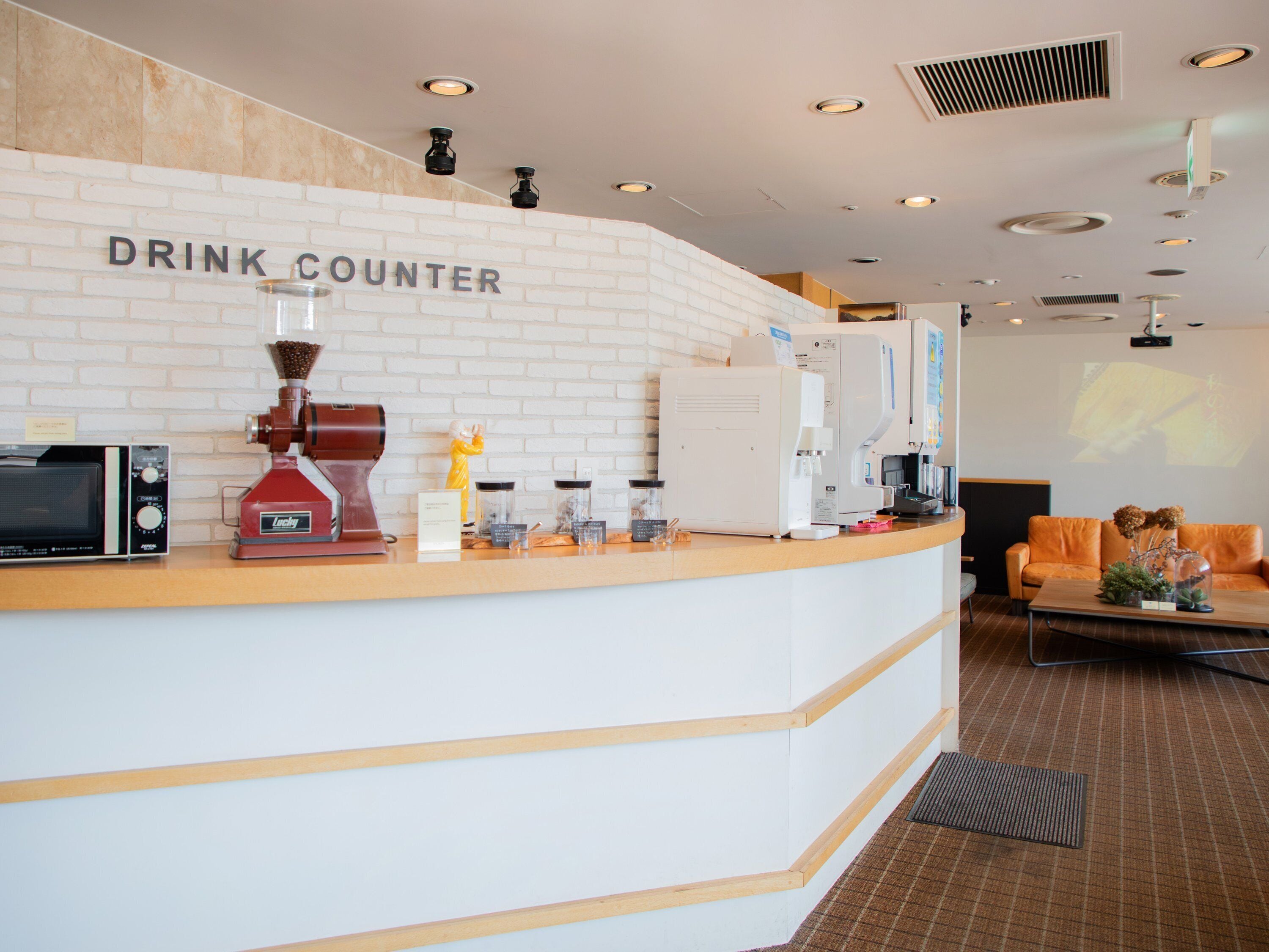 A modern drink counter with a coffee machine, a scale, and a coffee dispenser.