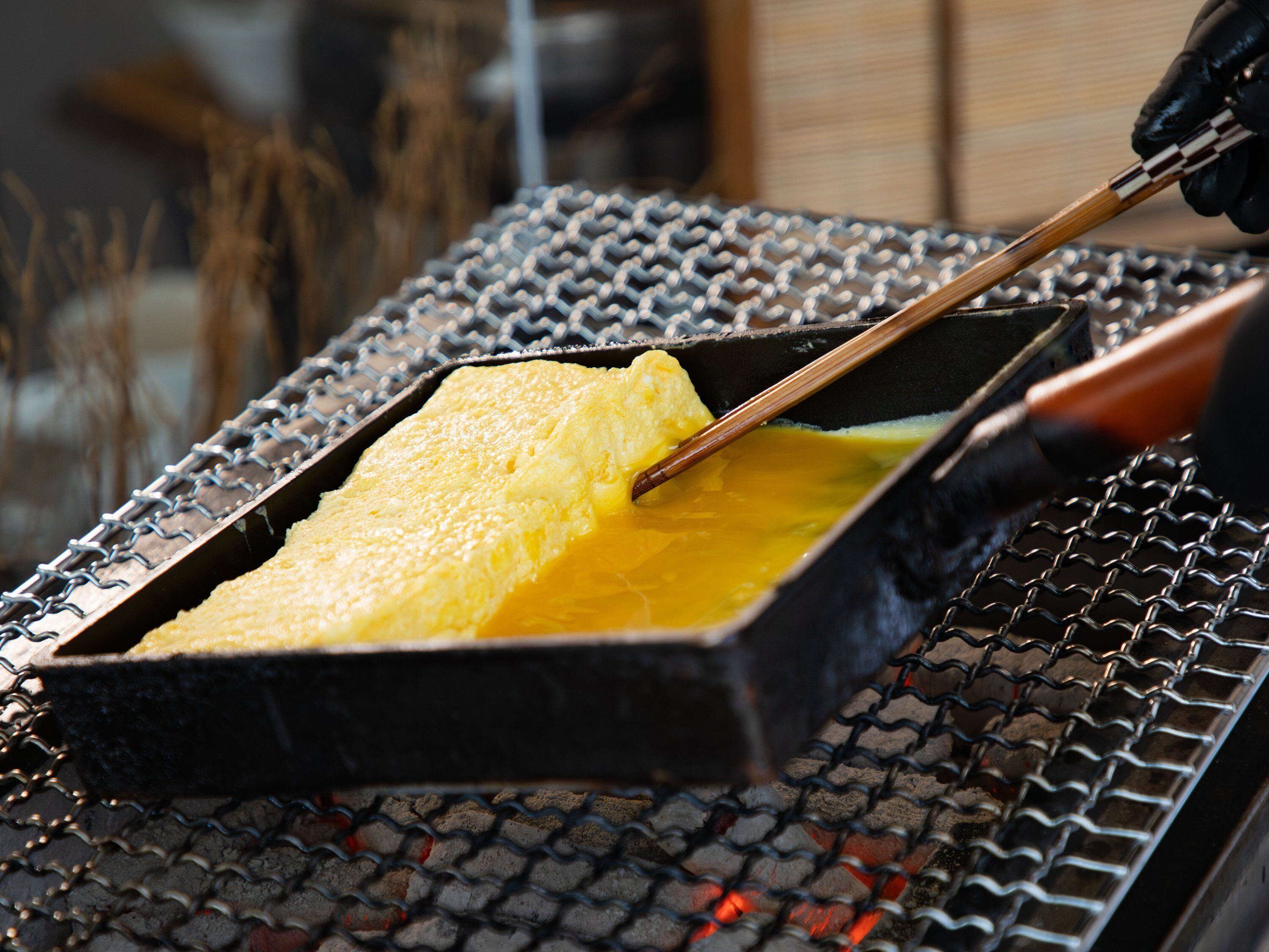 A cooking process with a metal grid surface and a rectangular pan.