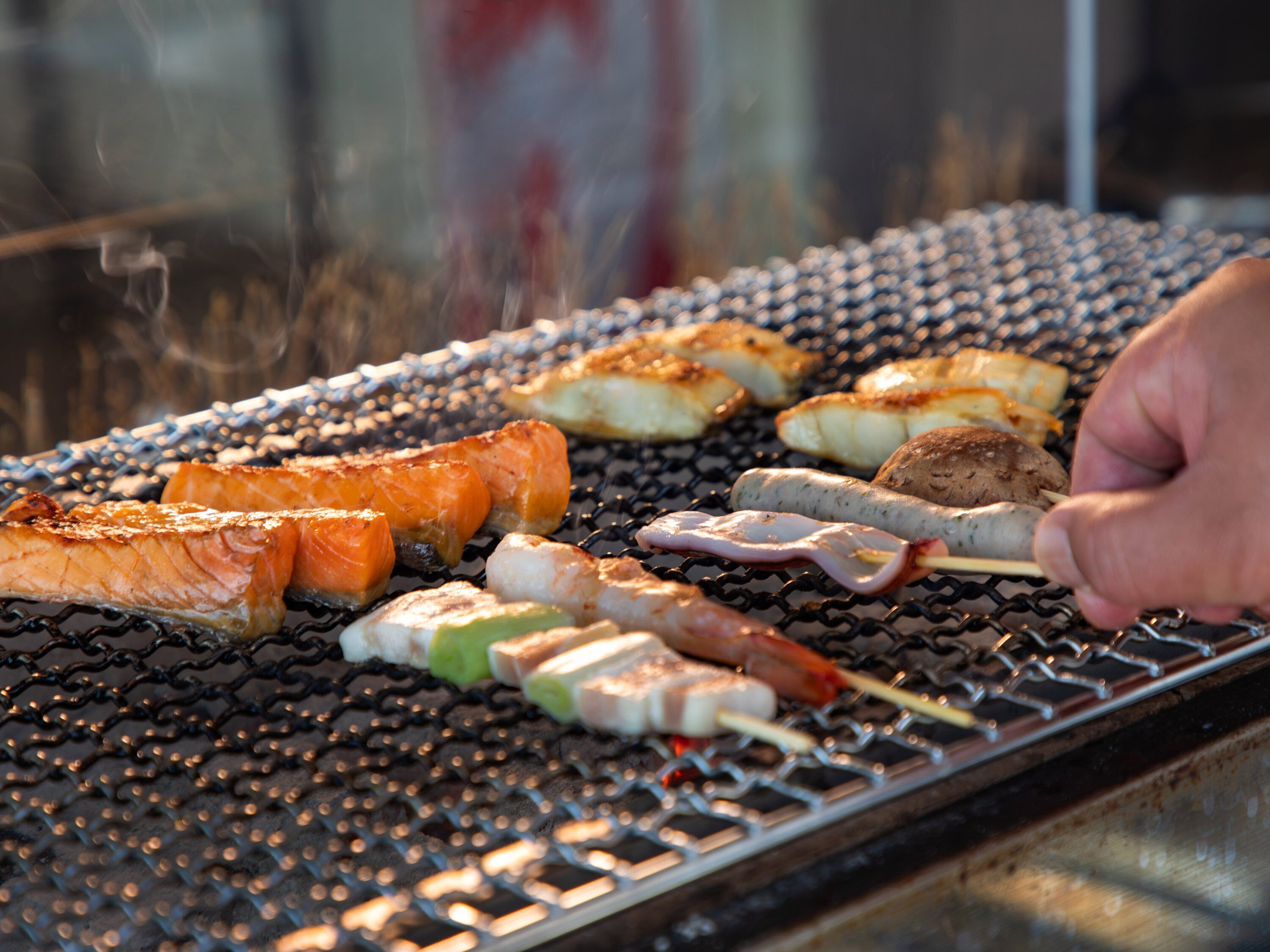 En grill med forskelligt kød og grøntsager, der tilberedes.