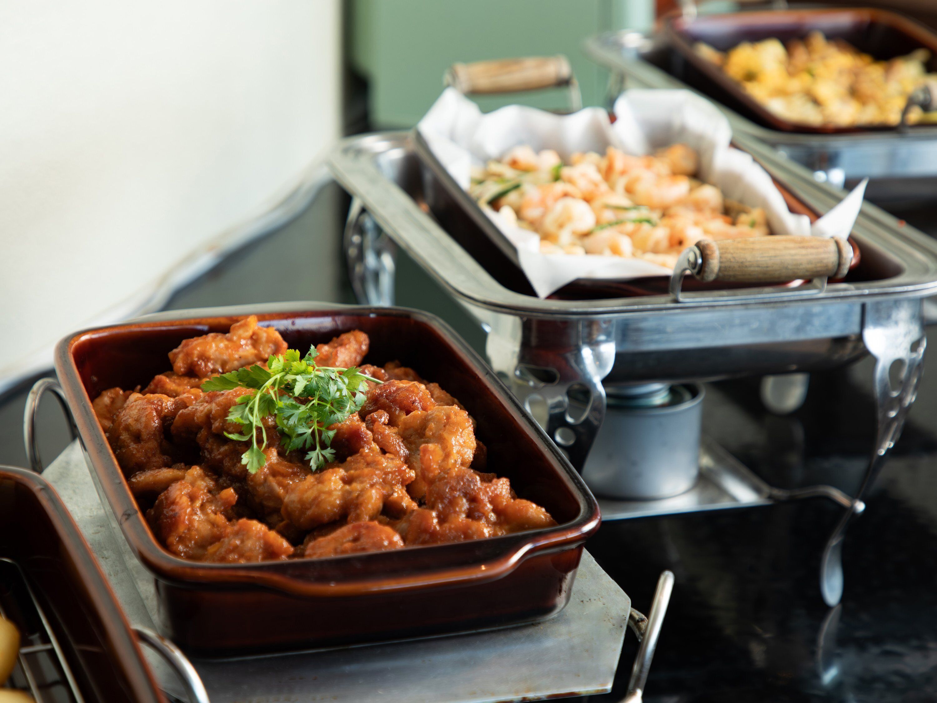Buffet com diversos pratos, incluindo um prato guarnecido com ervas.