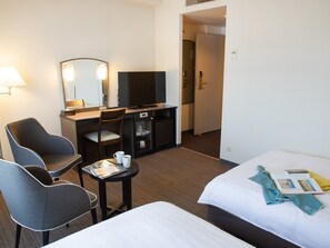 A hotel room with a bed, two chairs, a desk with a TV, and a small table with a cup and a book. - Hotel Resol Hakodate (Hakodate)