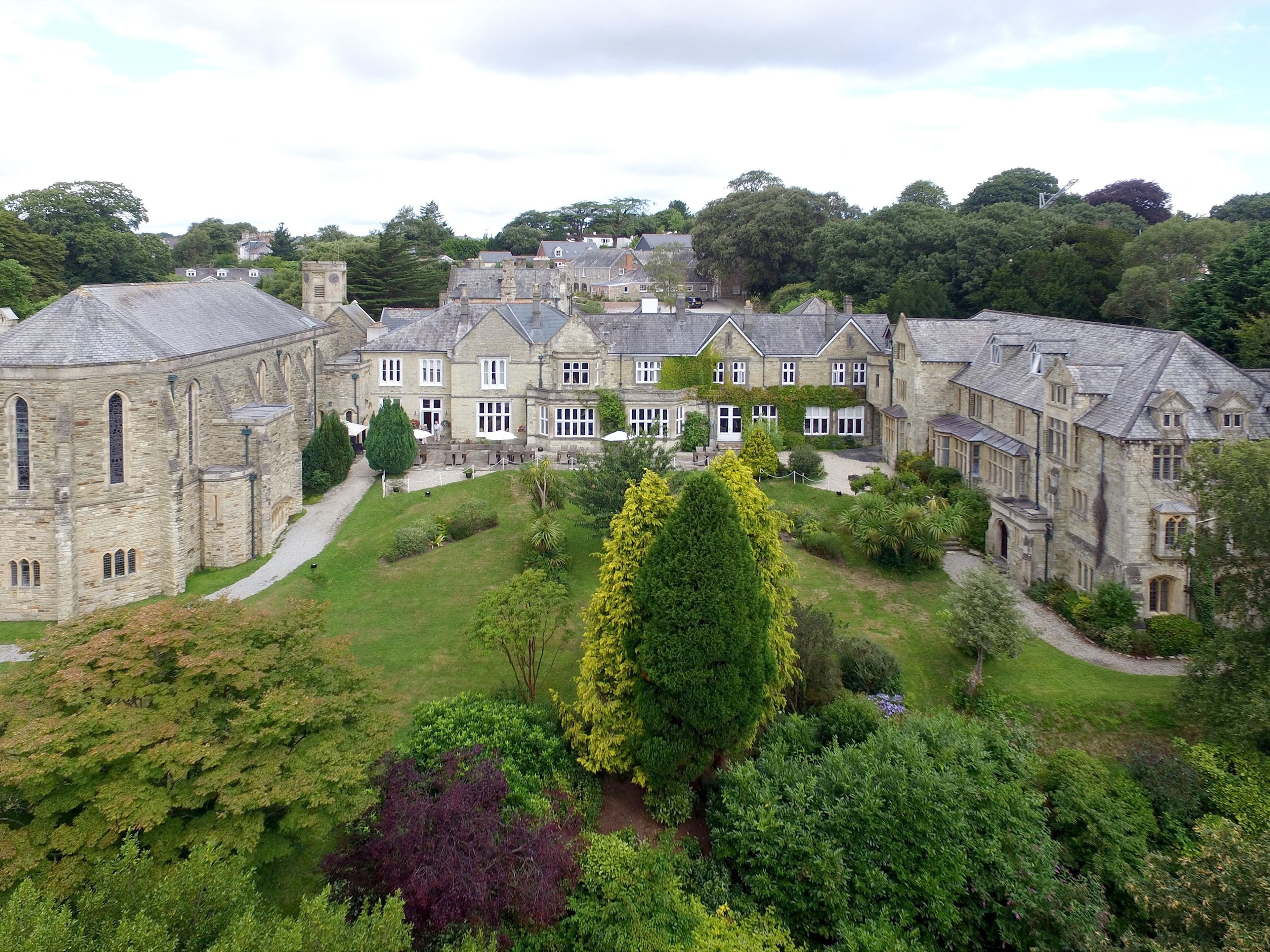 A historic stone building with multiple wings and a central courtyard.