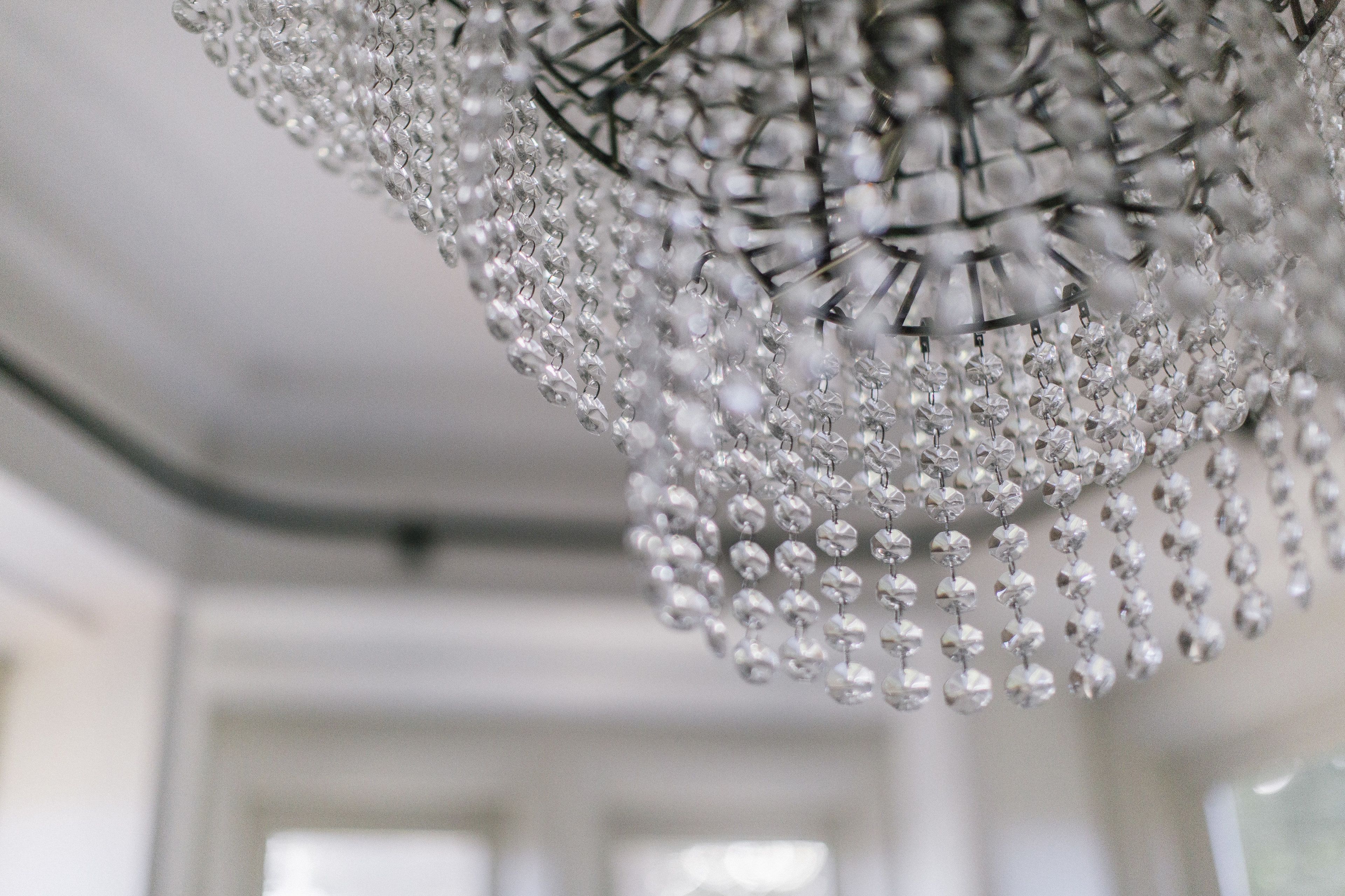 Un lustre orné de plusieurs niveaux de décorations en cristal transparent.