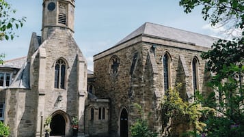 A historic stone church with a prominent clock tower and arched windows.