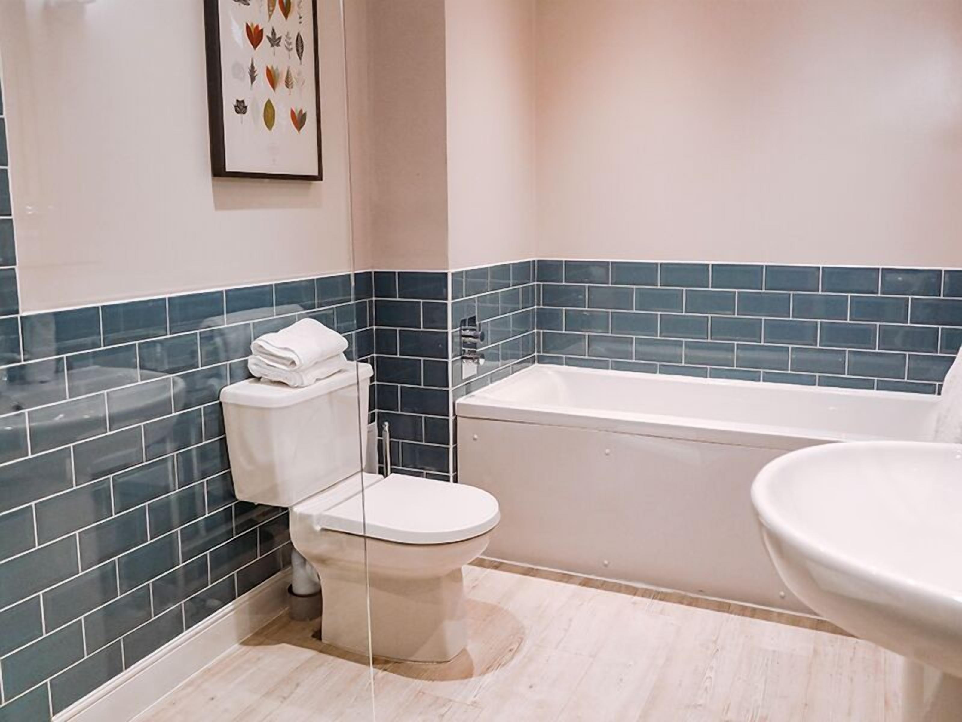 Un baño con inodoro, bañera y lavamanos.