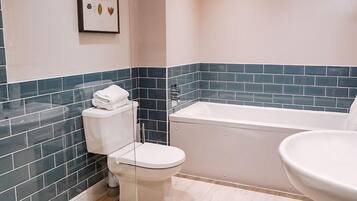 A bathroom with a toilet, bathtub, and sink.