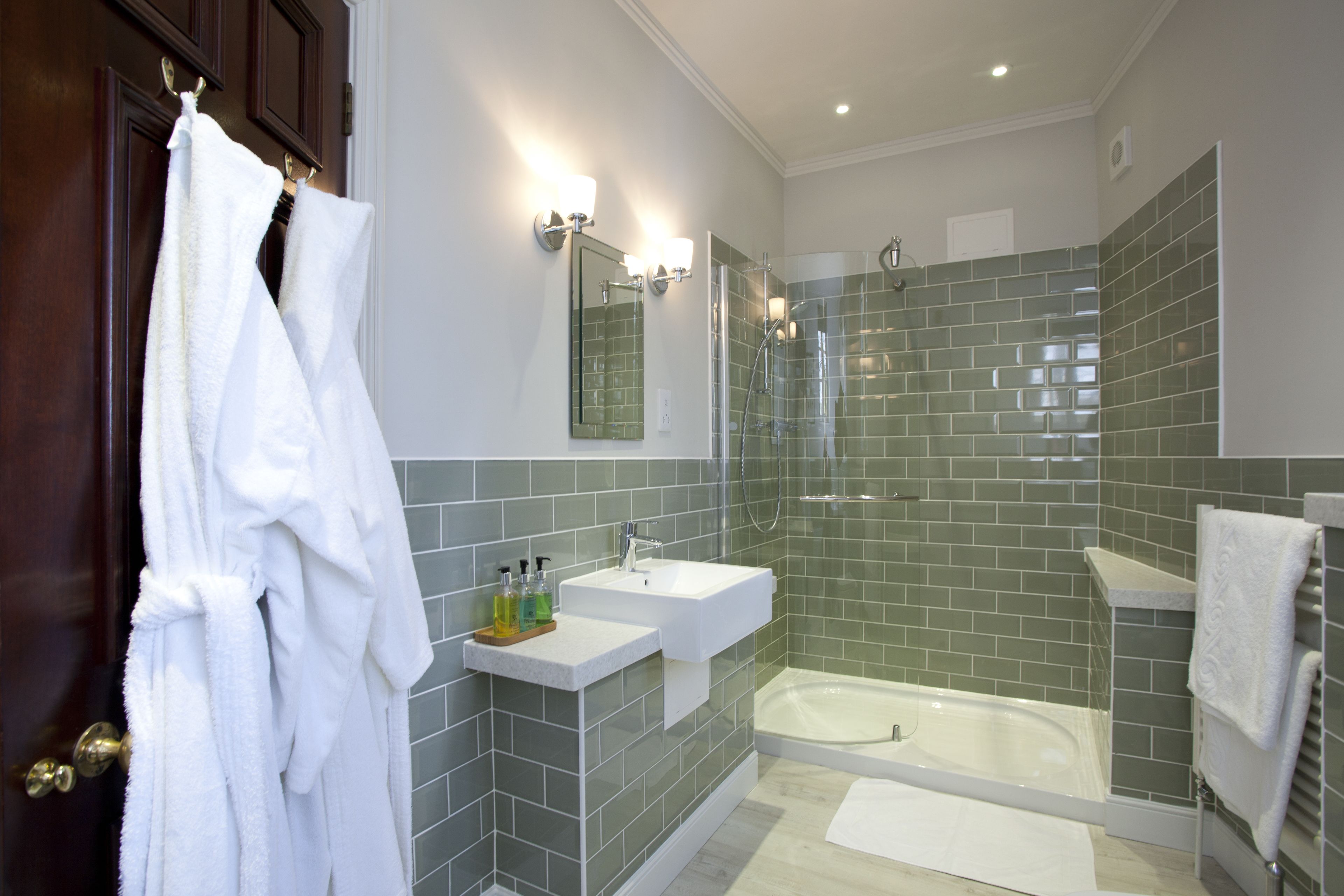 A modern bathroom with a glass-enclosed shower, a white sink, and a bathtub.