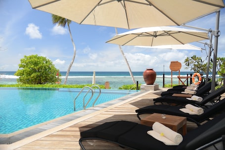 Outdoor pool, sun loungers. DoubleTree by Hilton Seychelles - Allamanda Resort & Spa